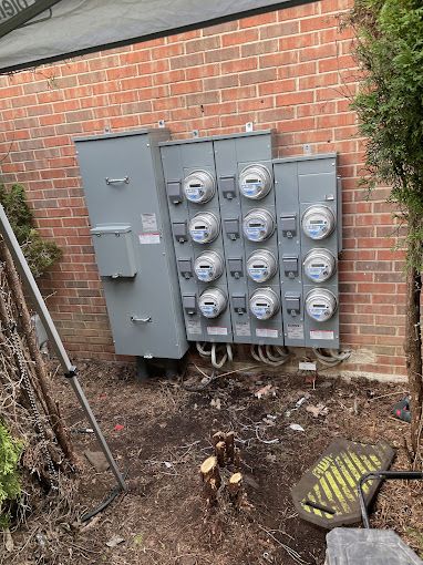 A brick wall with a bunch of electrical meters on it.