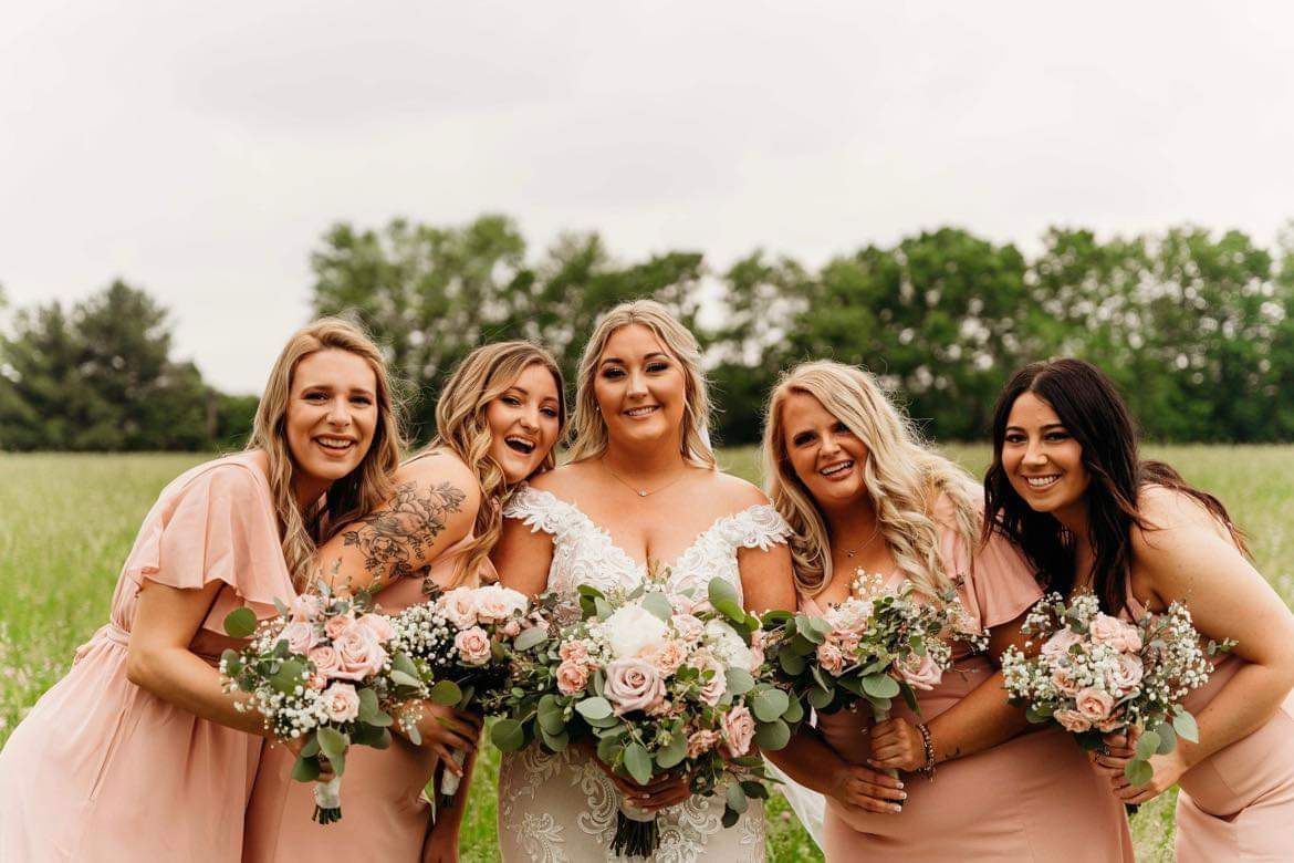 Four bodybuilders in a hallway pose shirtless. They wear colorful shorts and have tanned skin.