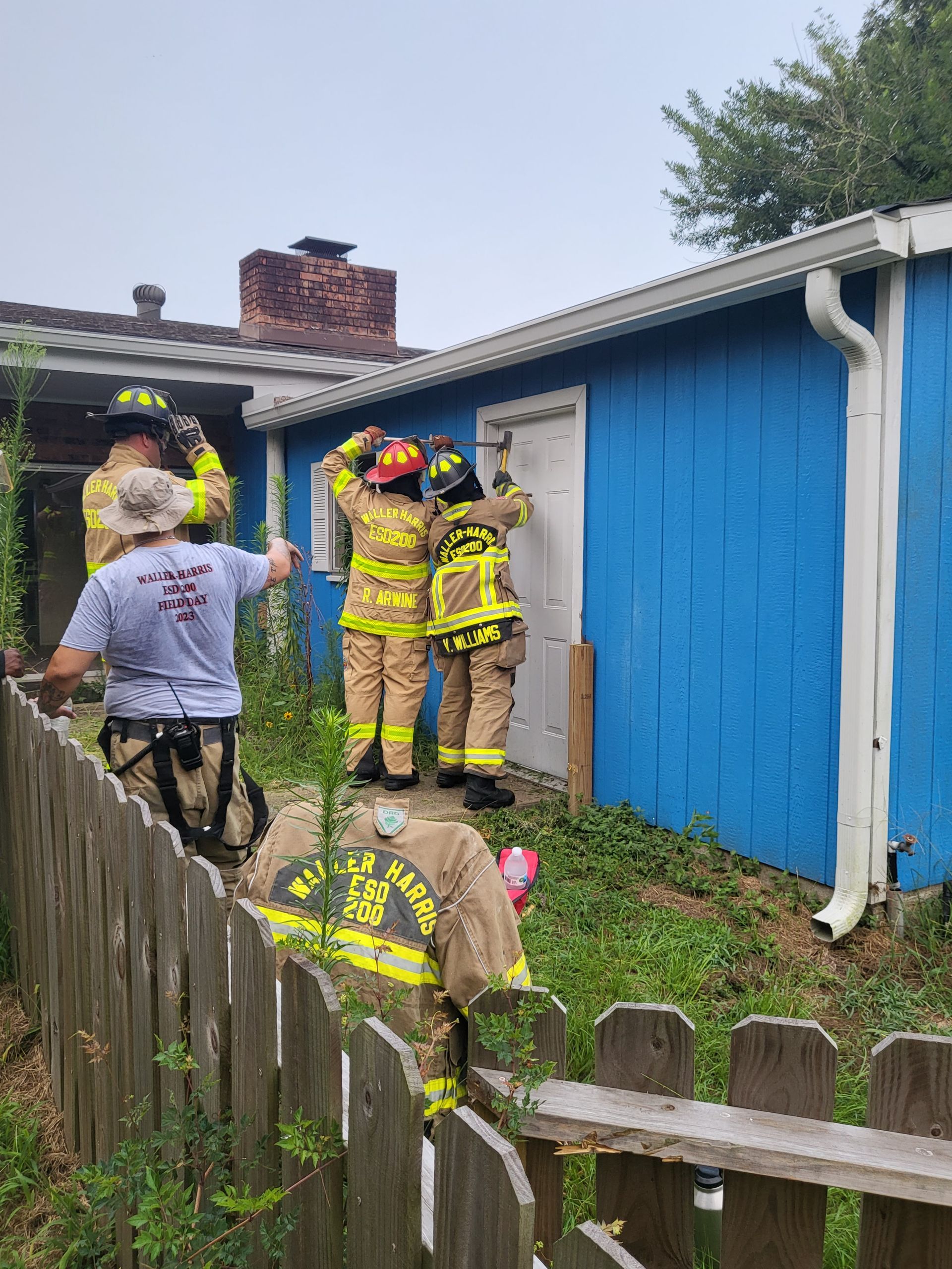 A group of fire fighters trying to breach a door during a training exercise.
