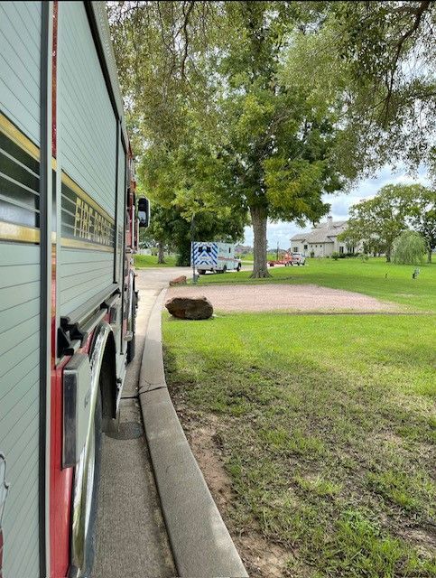A fire truck is parked on the side of the road in a park