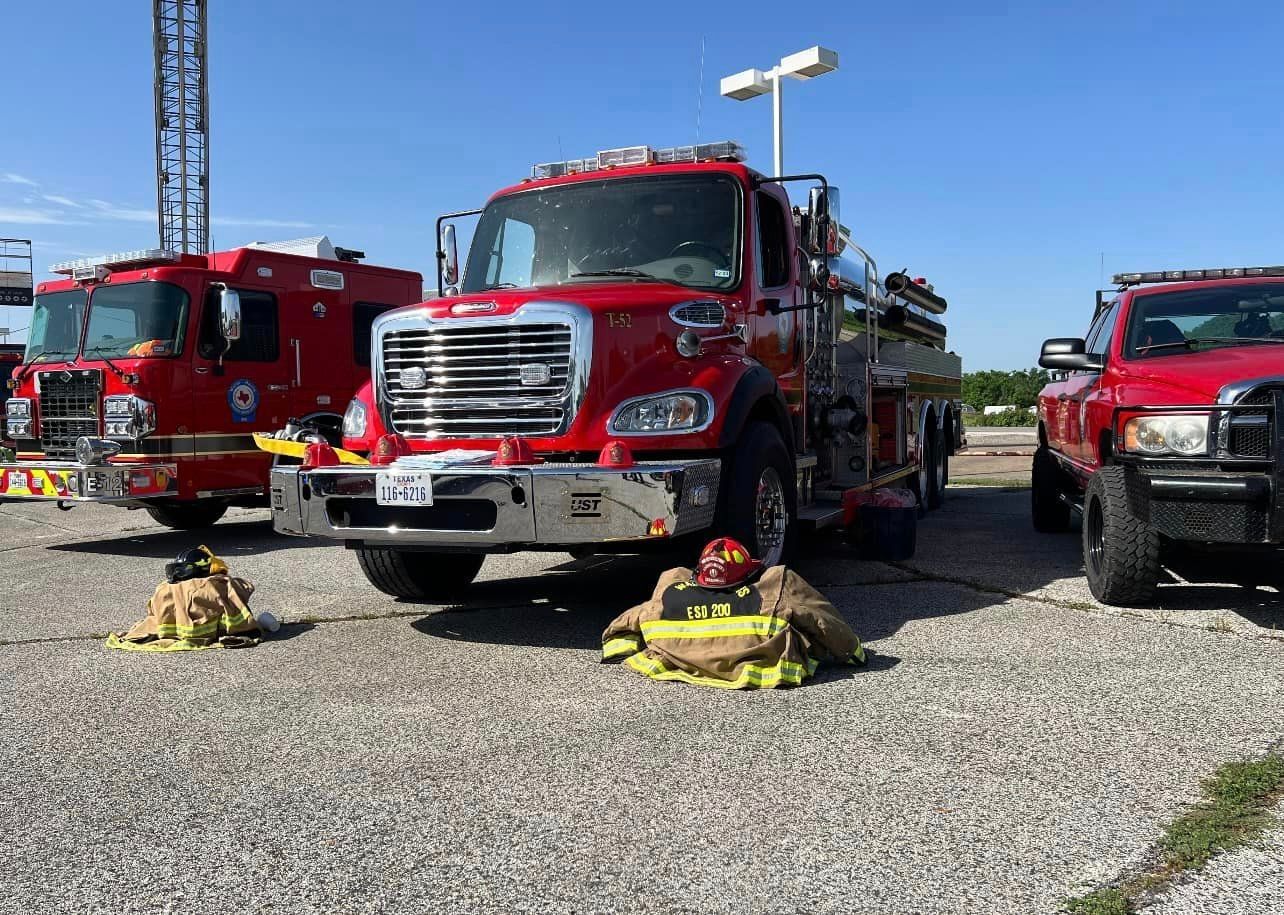A group of fire trucks are parked next to each other in a parking lot.