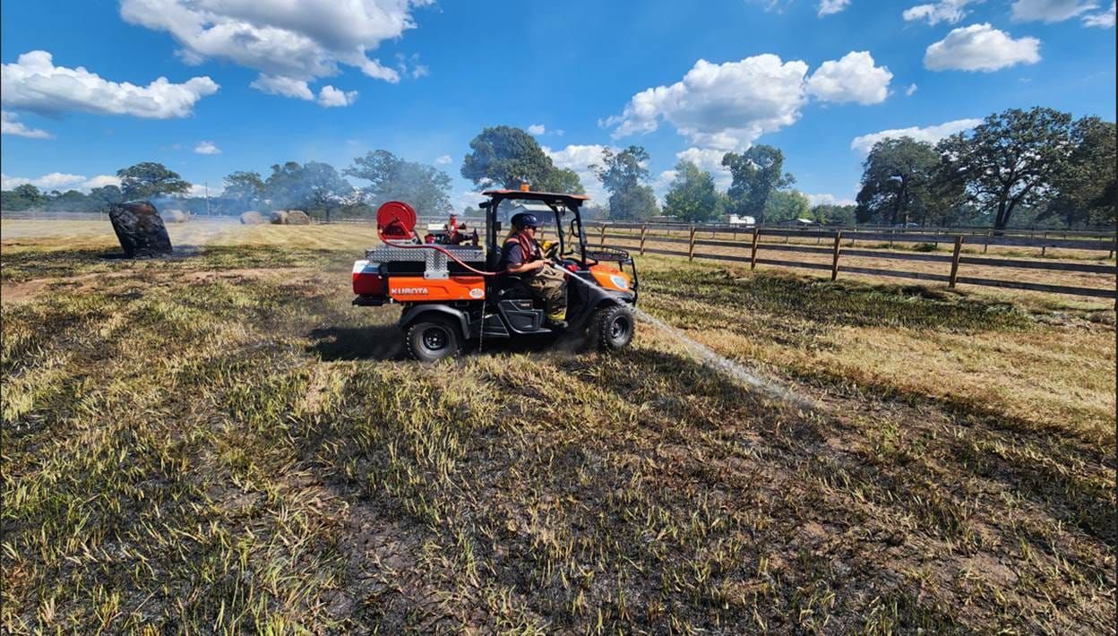 A man is driving a tractor through a field.