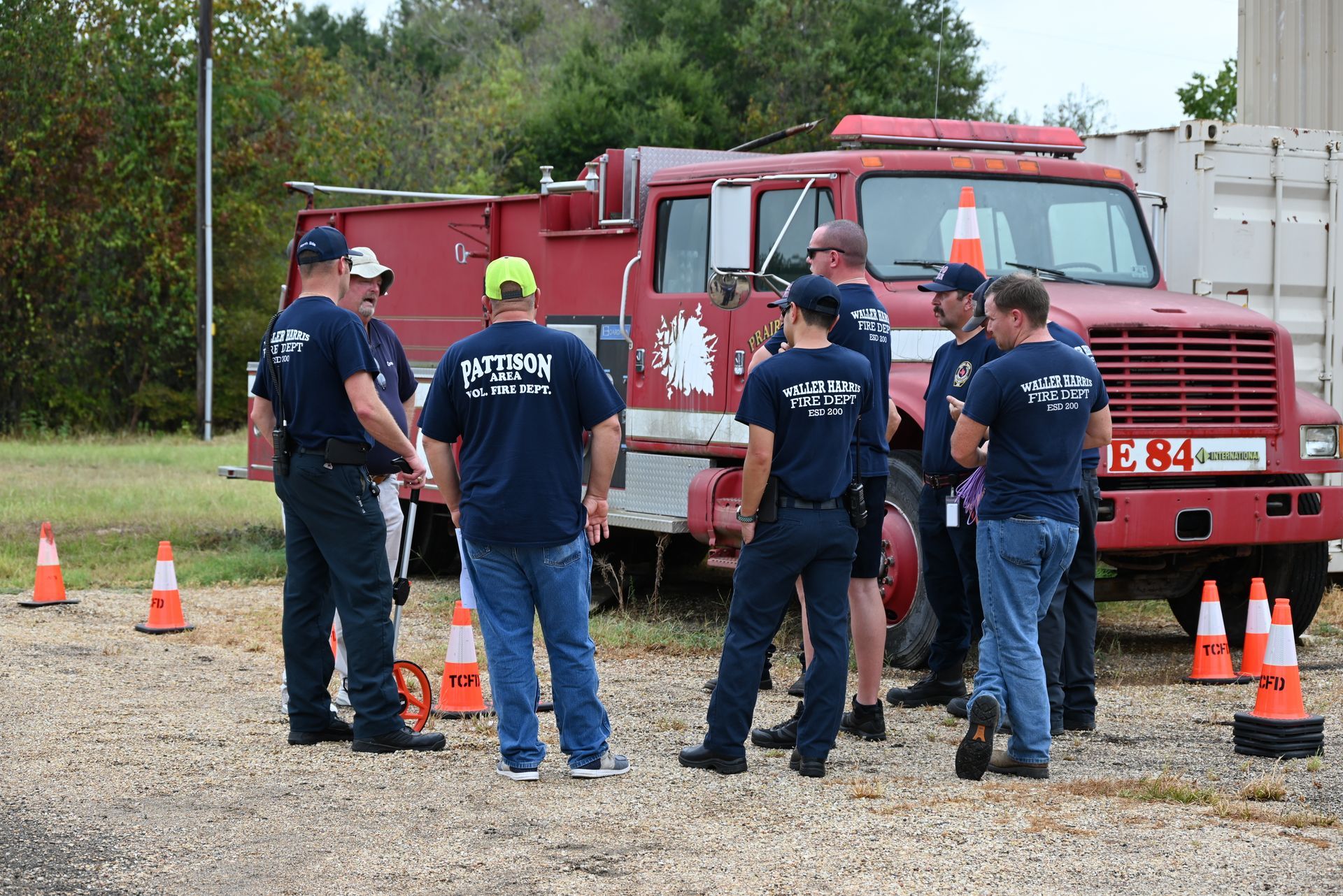 A group of fire fighters are standing in front of a fire truck.