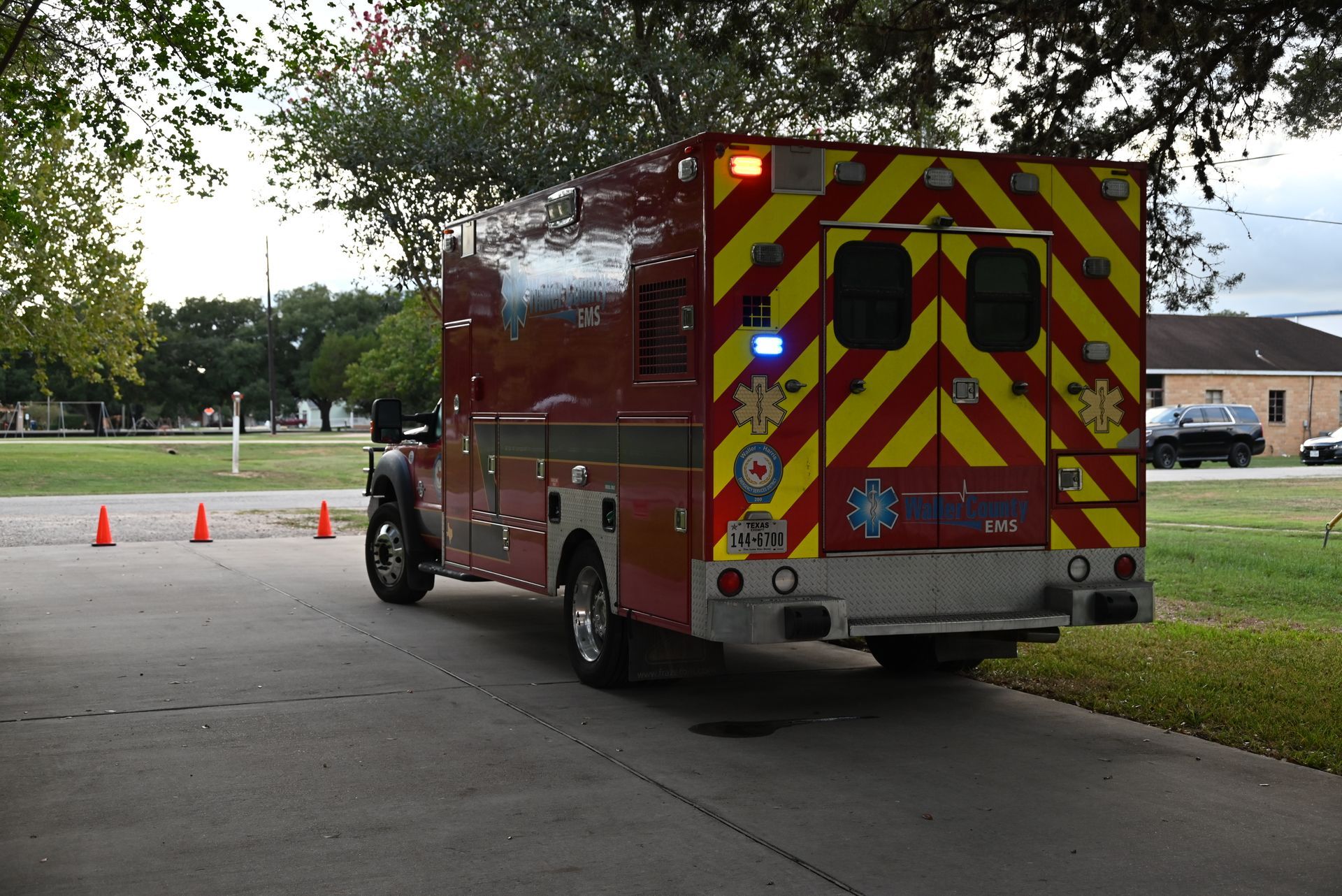A red and yellow ambulance is parked on the side of the road.