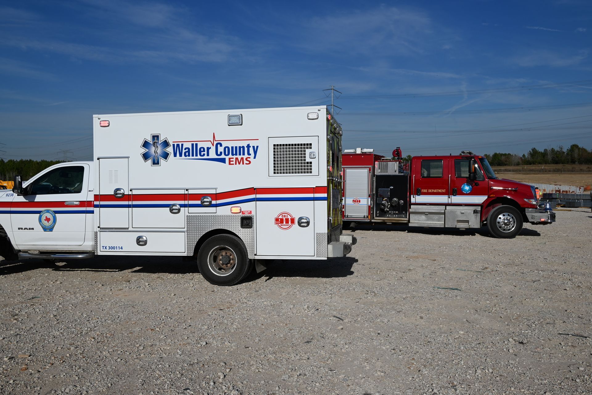 An ambulance from waller county is parked next to a fire truck