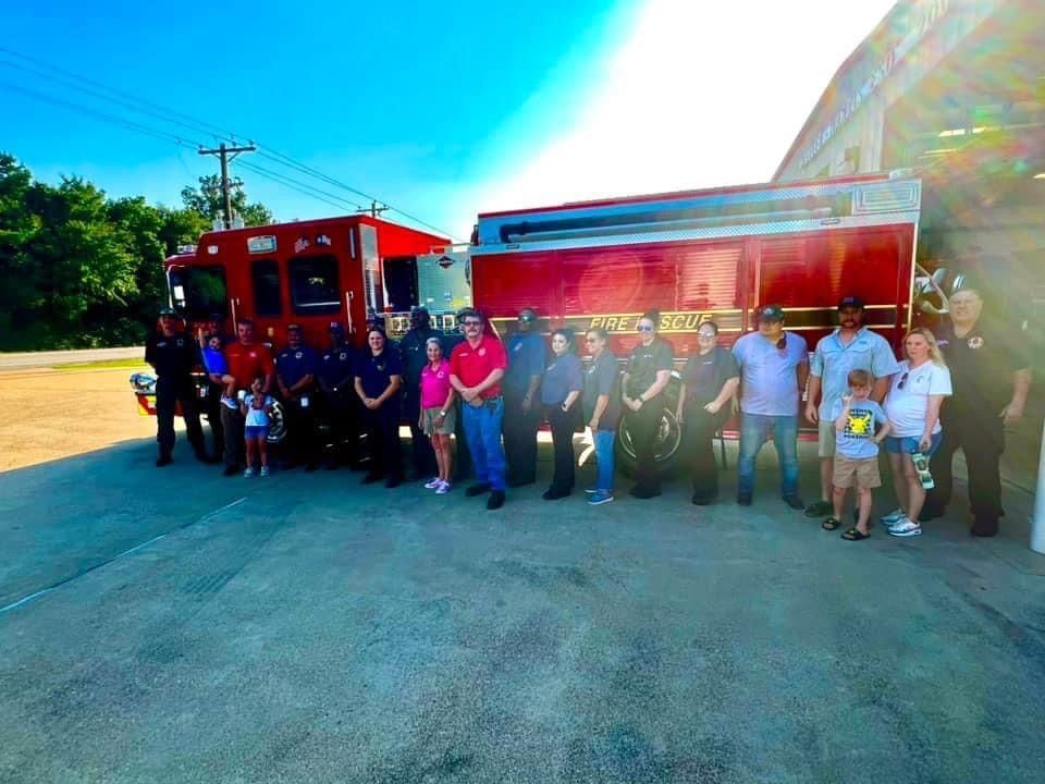 A group of people standing in front of a fire truck