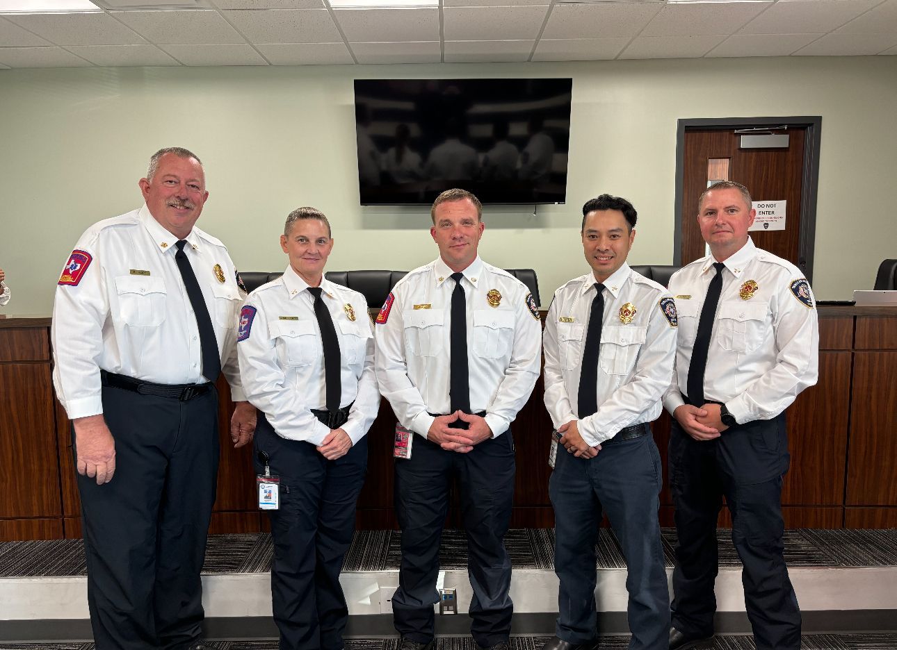A fire tanker truck is parked next to tanks of water.