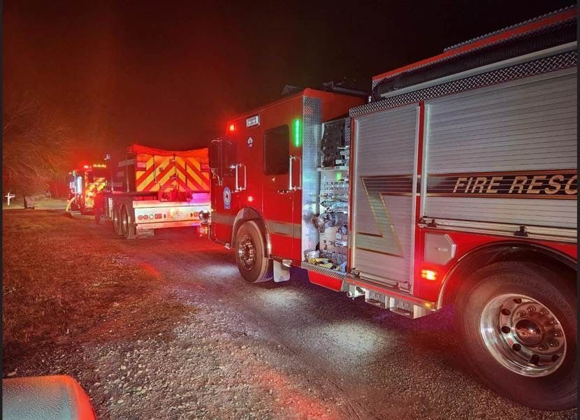 Fire fighters spray water on a vehicle fire.