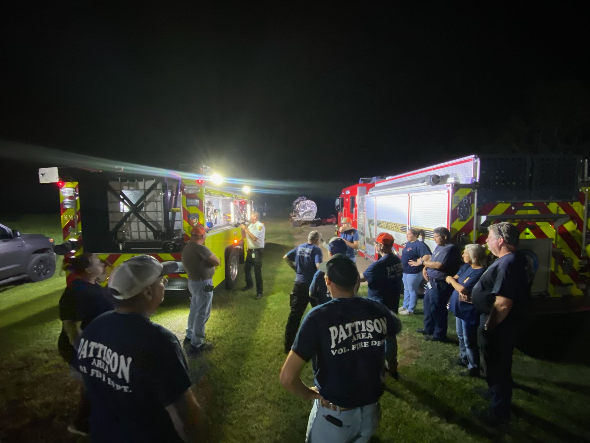 A group of people are standing in front of a fire truck.