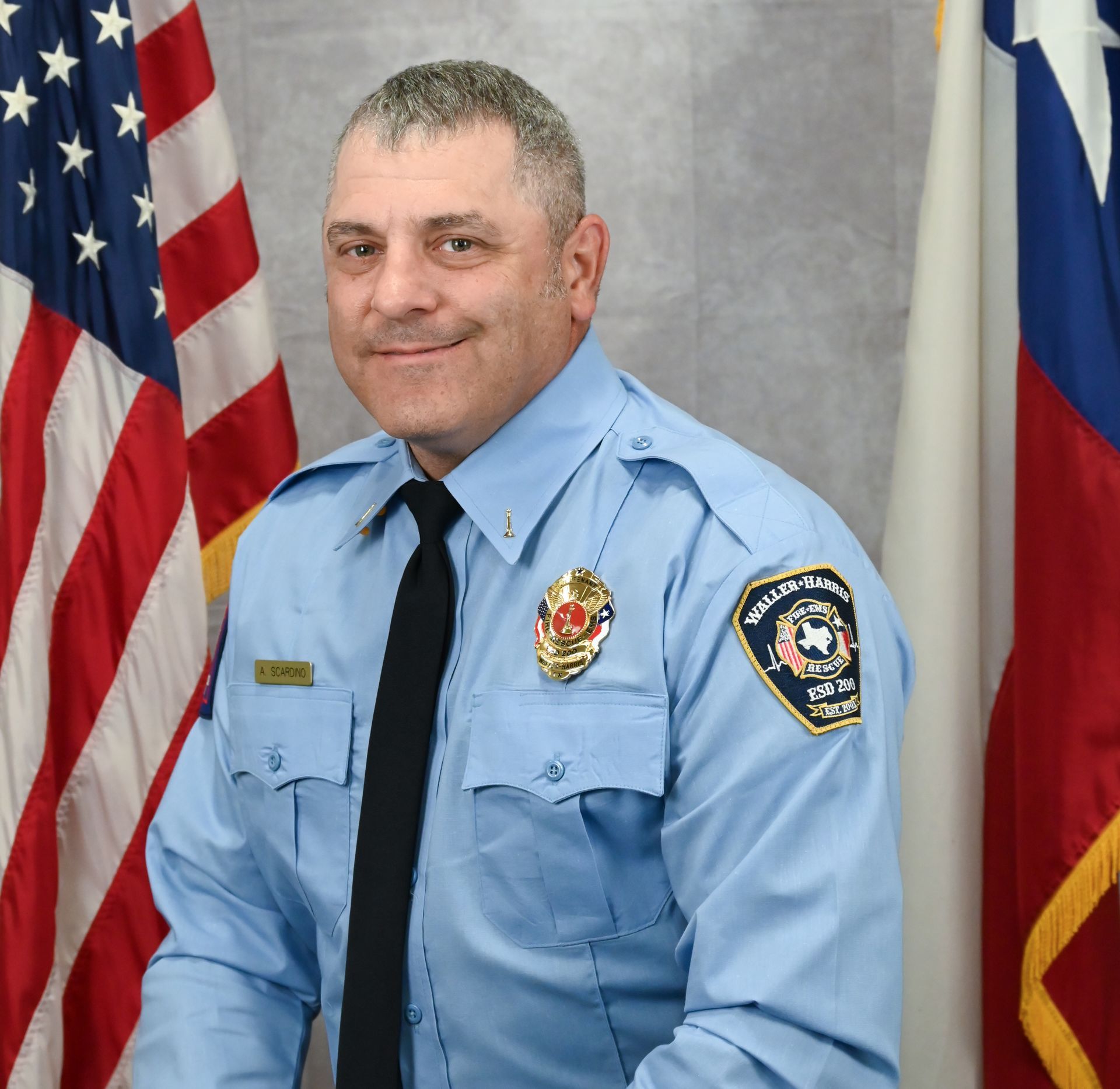 A picture of Commissioner Melinda Hashaw in a gray shirt in front of an American flag.