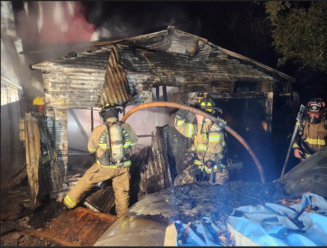 A group of firefighters are working on a house fire.