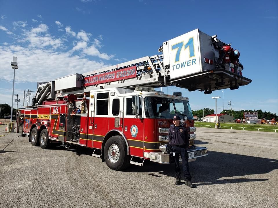 A man is standing in front of a fire truck with the number 71 on it