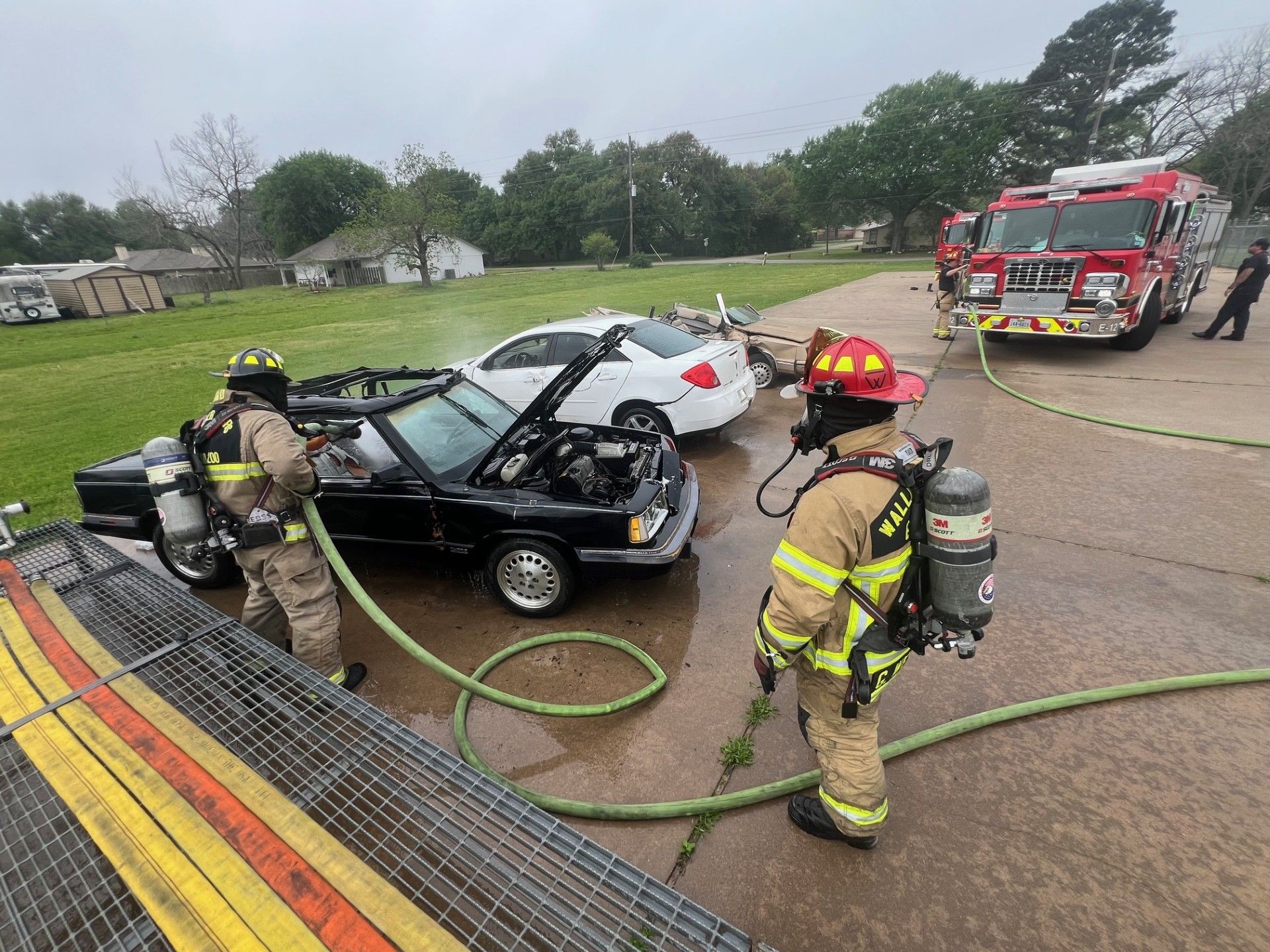 A group of firefighters are working on a car fire.