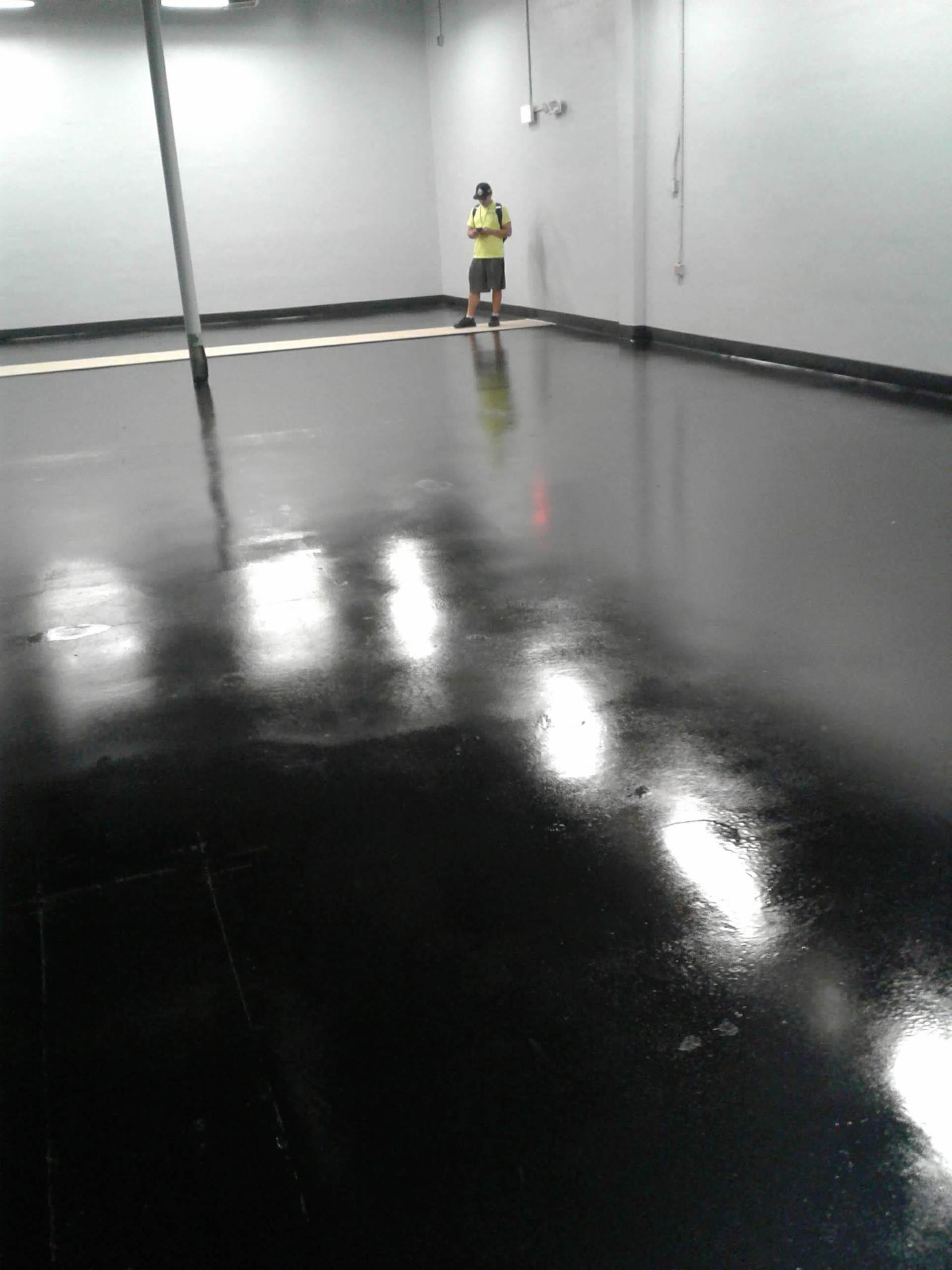 A man is standing in a room with a black floor.