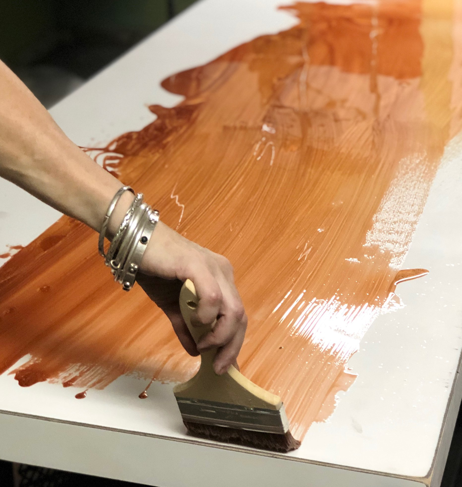 A person is painting a table with a brush