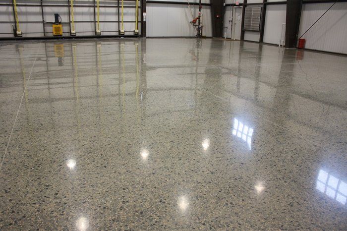 A large warehouse with a shiny concrete floor