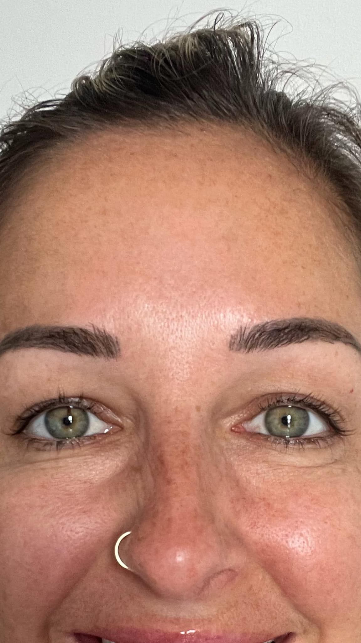 A Close up Of a Woman 's Face with Green Eyes and A Nose Ring — Palm Beach Currumbin Injectables in Currumbin, QLD