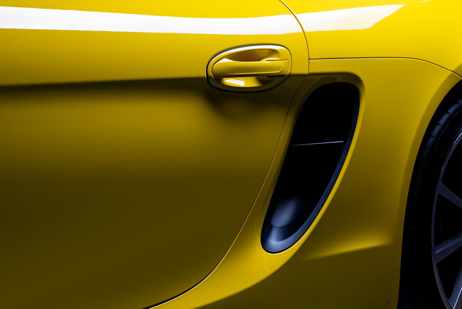 A close up of the side of a yellow sports car