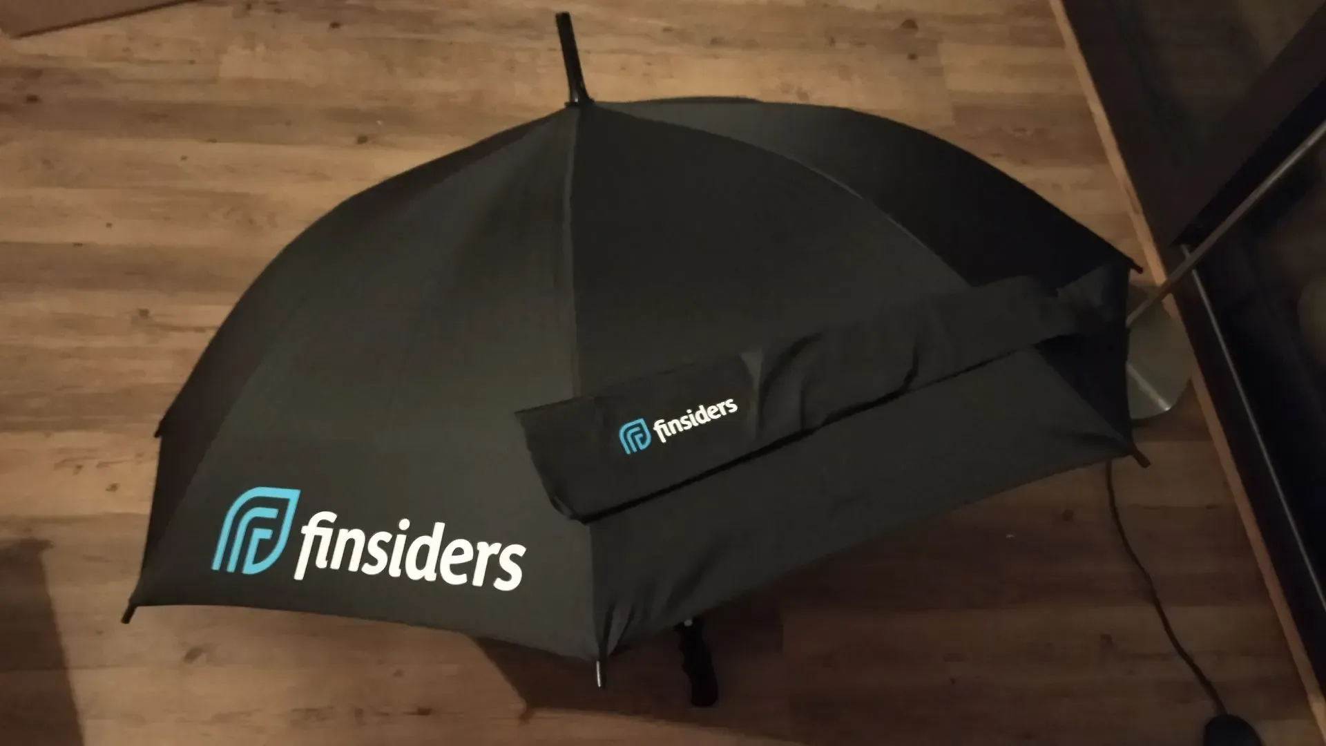 zwarte paraplu met finsiders erop