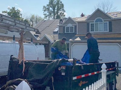 Two men are working on the roof of a house.