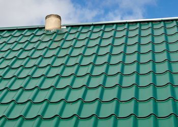 A green roof with a chimney on top of it.