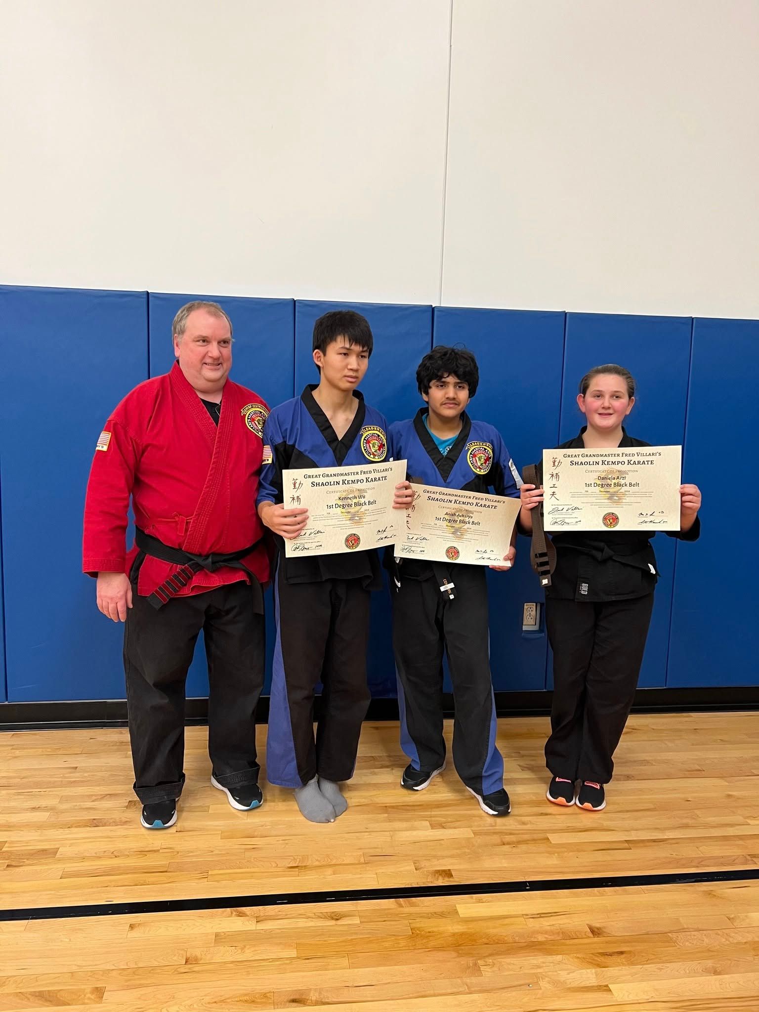 a group of people are watching two people wrestling on a mat .