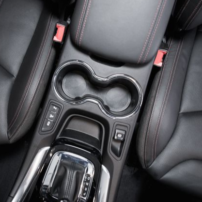 Black car interior with leather seats, cup holders, and gear shift.