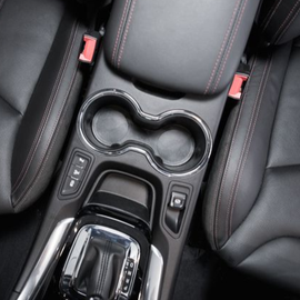 Black car interior with leather seats, cup holders, and gear shift.