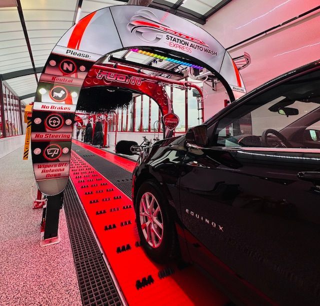 A black car is going through an automatic car wash