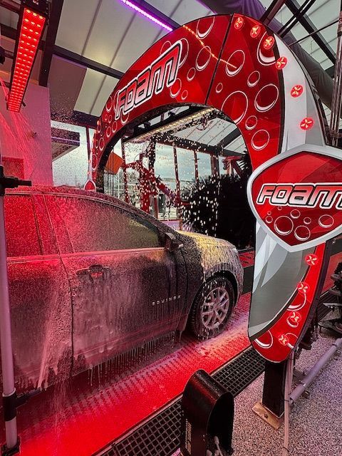 A car is being washed in a car wash with foam