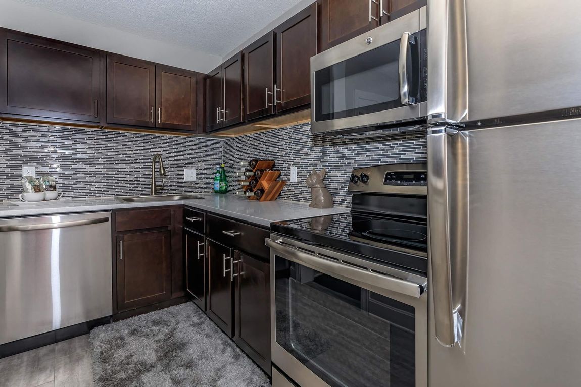 A kitchen with stainless steel appliances and wooden cabinets.