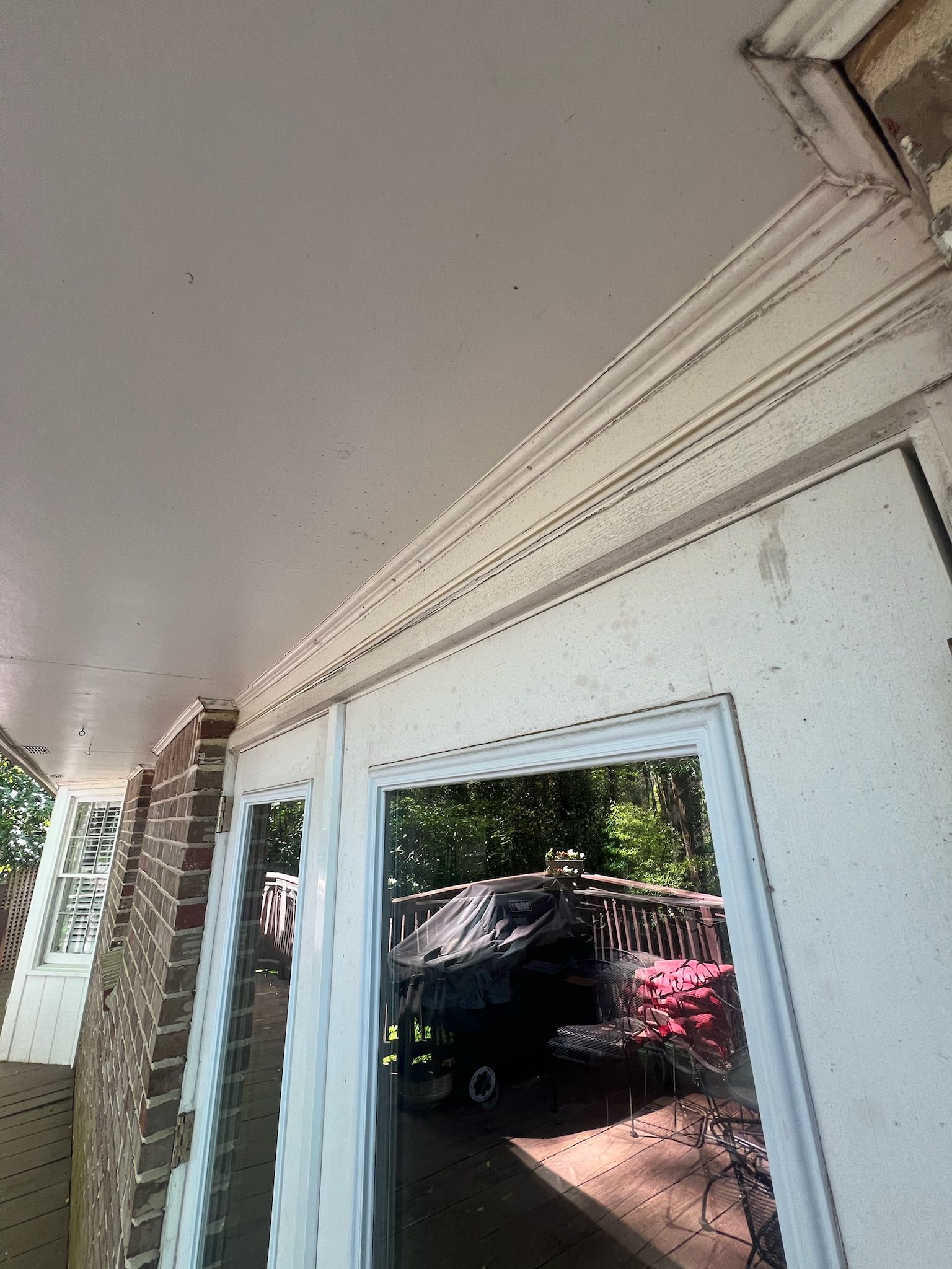 A door with a mirror on it is open to a porch.