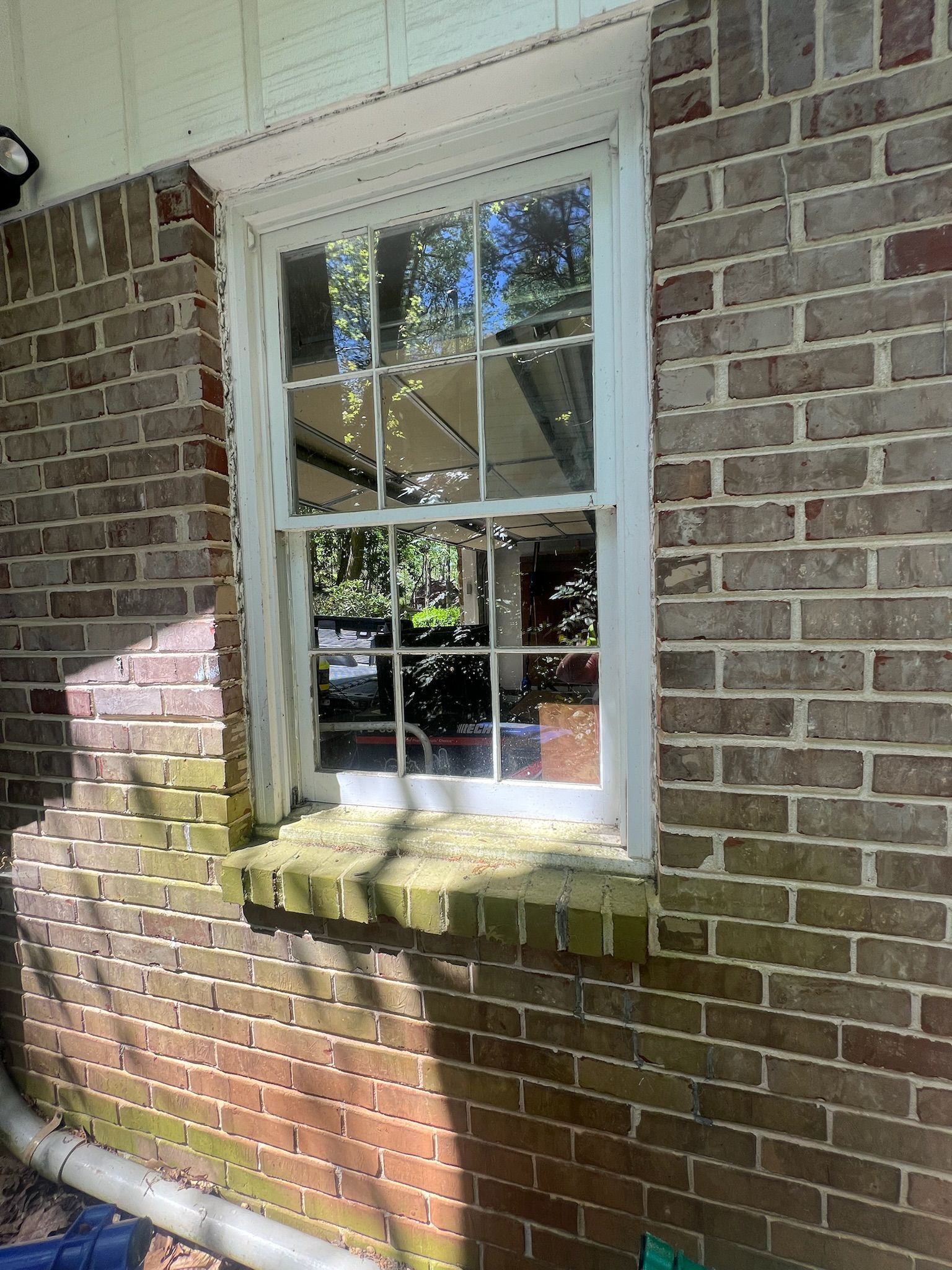 A brick wall with a white window on it.