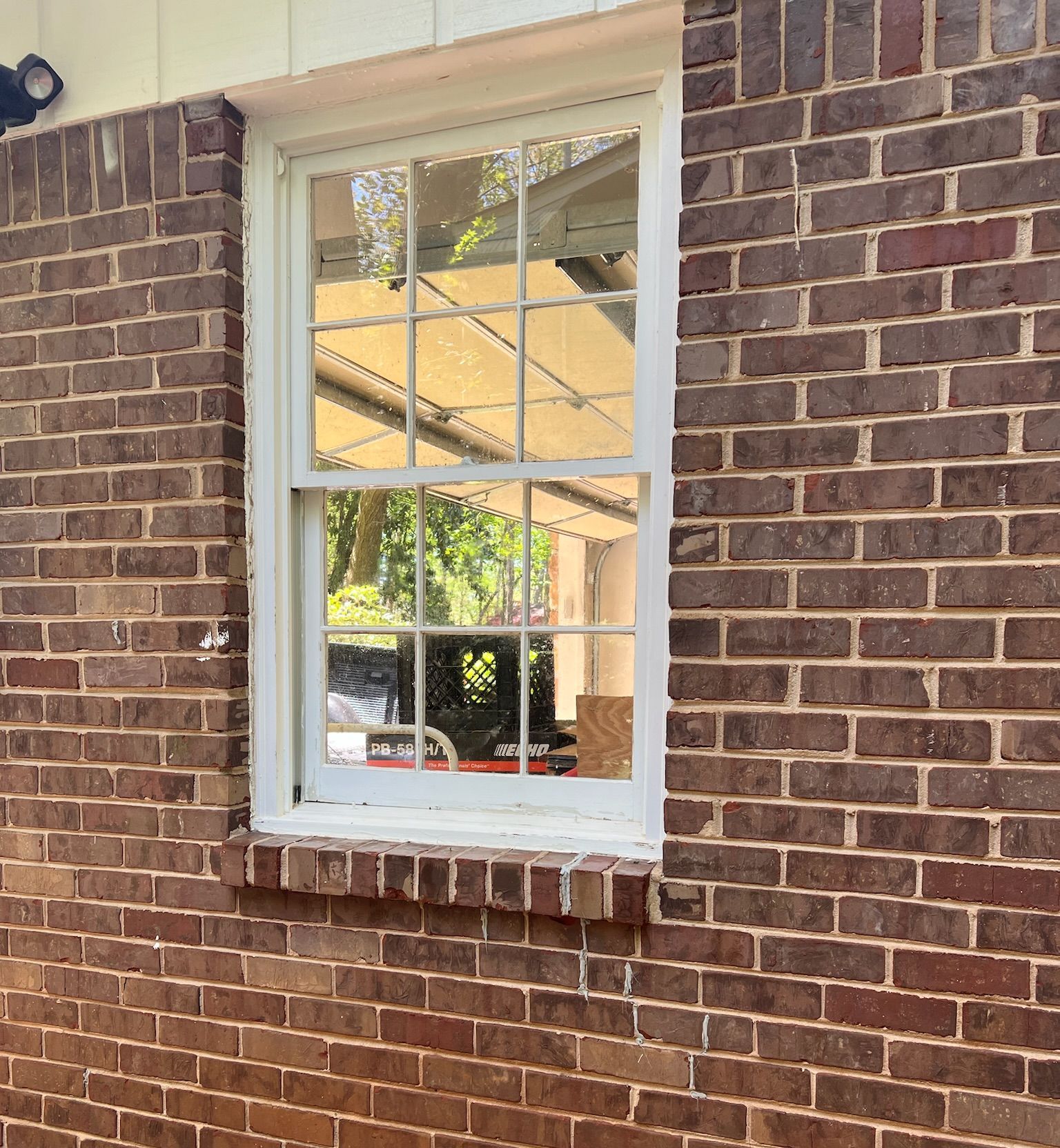 A brick wall with a white window on it