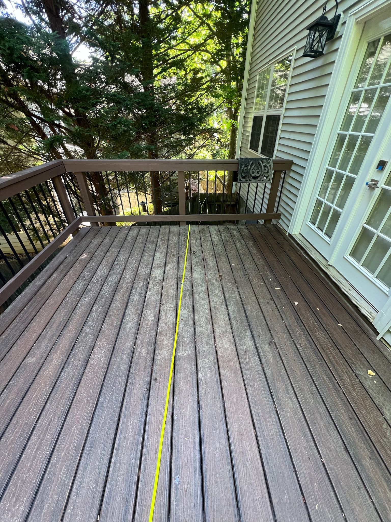 A wooden deck with a yellow line on it next to a house.