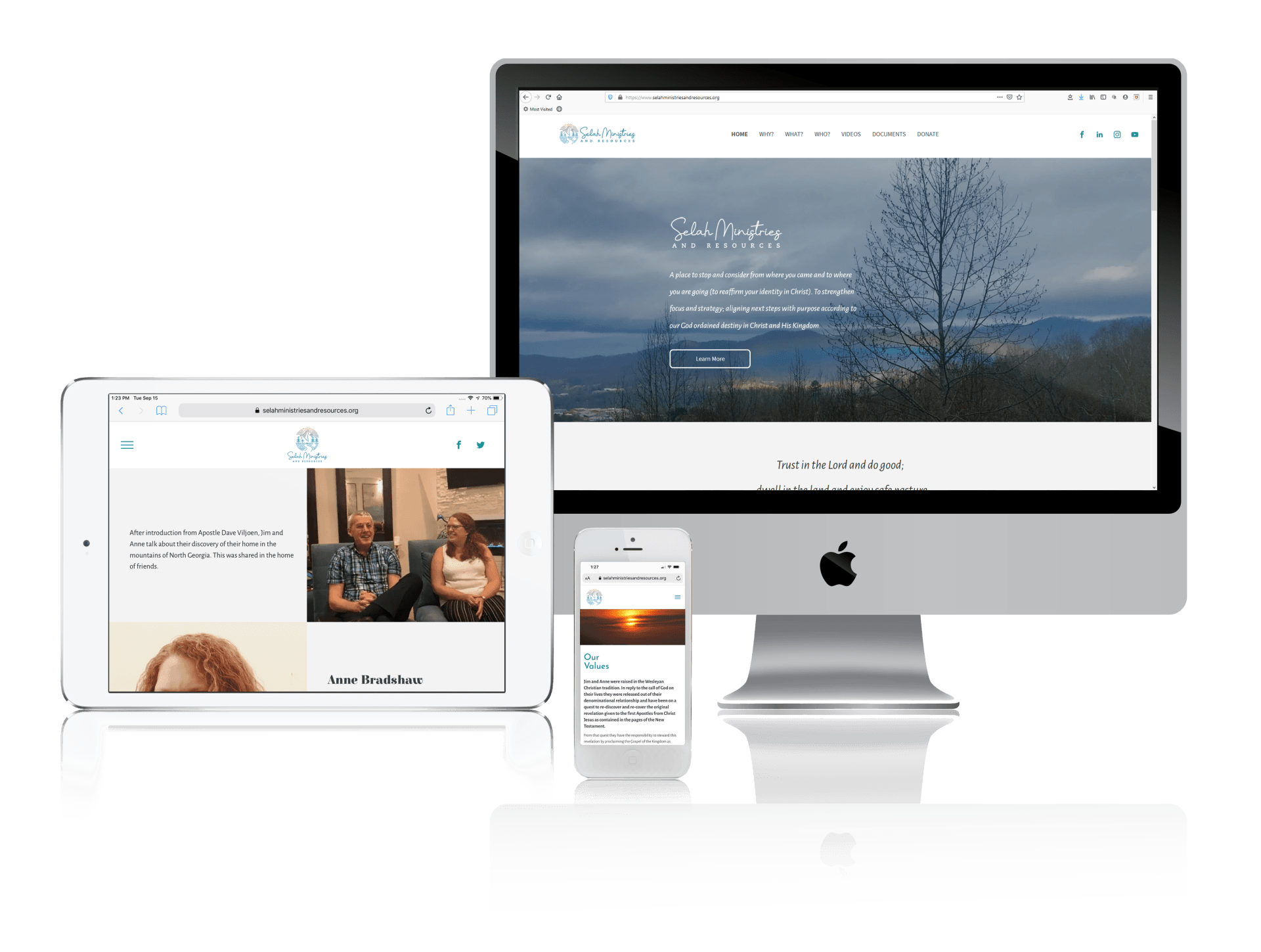 A computer , tablet , and cell phone are sitting next to each other on a table.