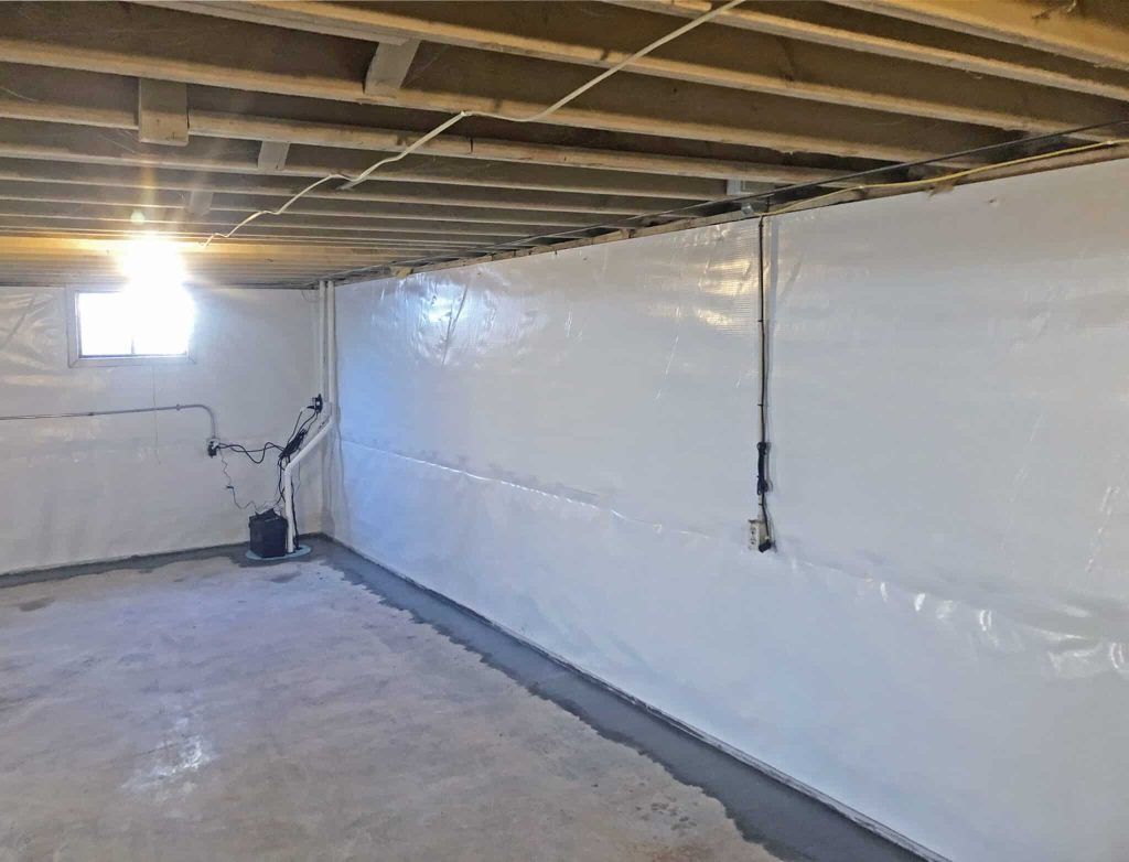 Basement with white waterproof walls and concrete floor.