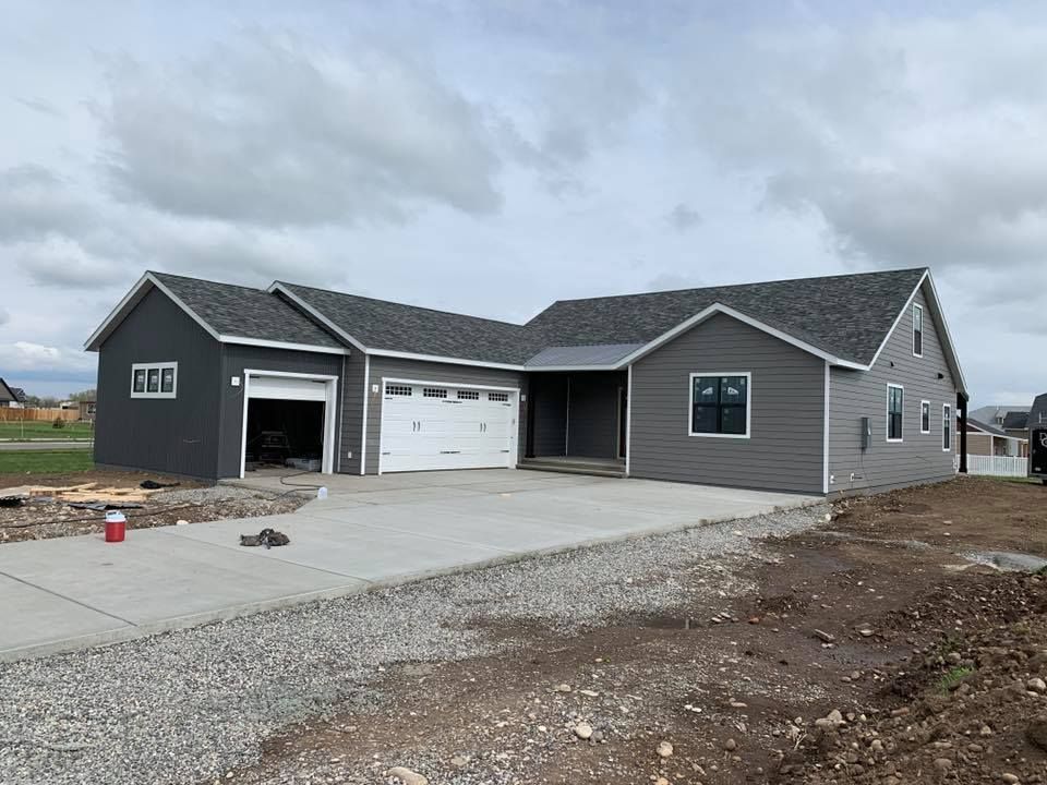 Two men are standing in an empty room with black walls