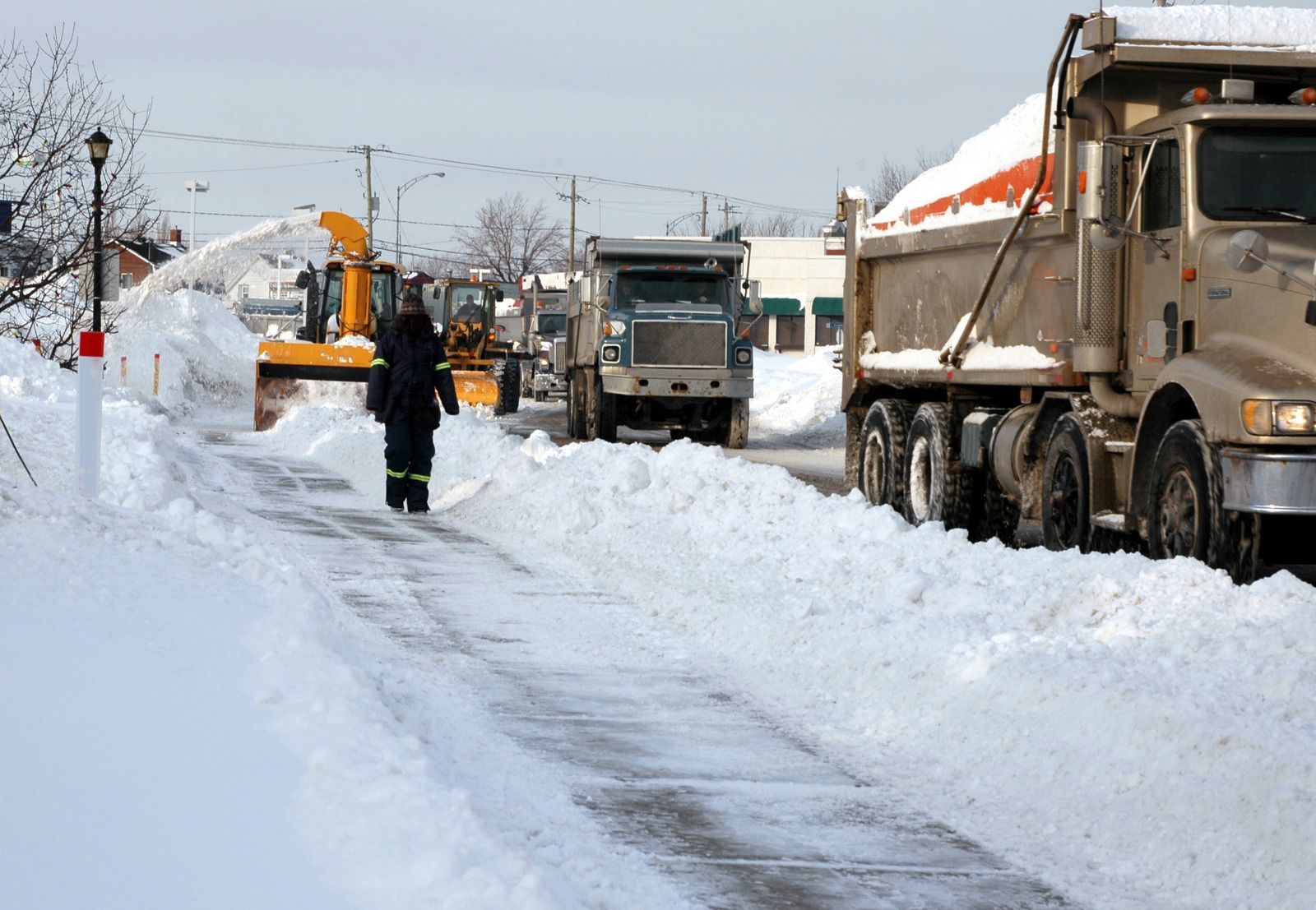 A yellow excavator is sitting on top of a pile of gravel.