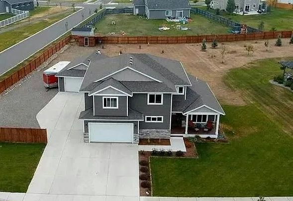 A yellow excavator is sitting on top of a pile of gravel.