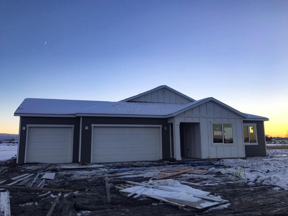 A construction worker wearing a blue hard hat is working on a roof