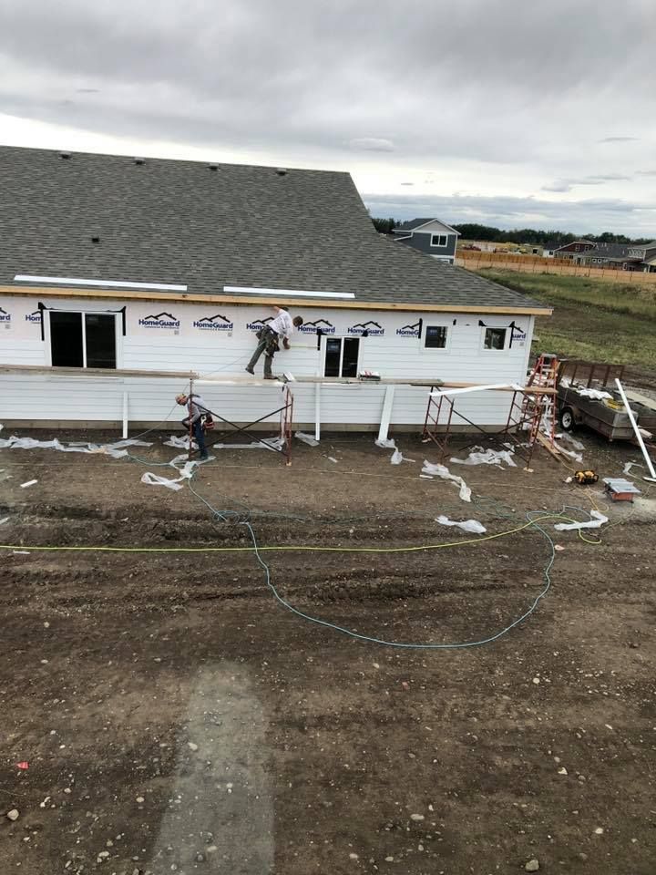 A yellow excavator is sitting on top of a pile of gravel.
