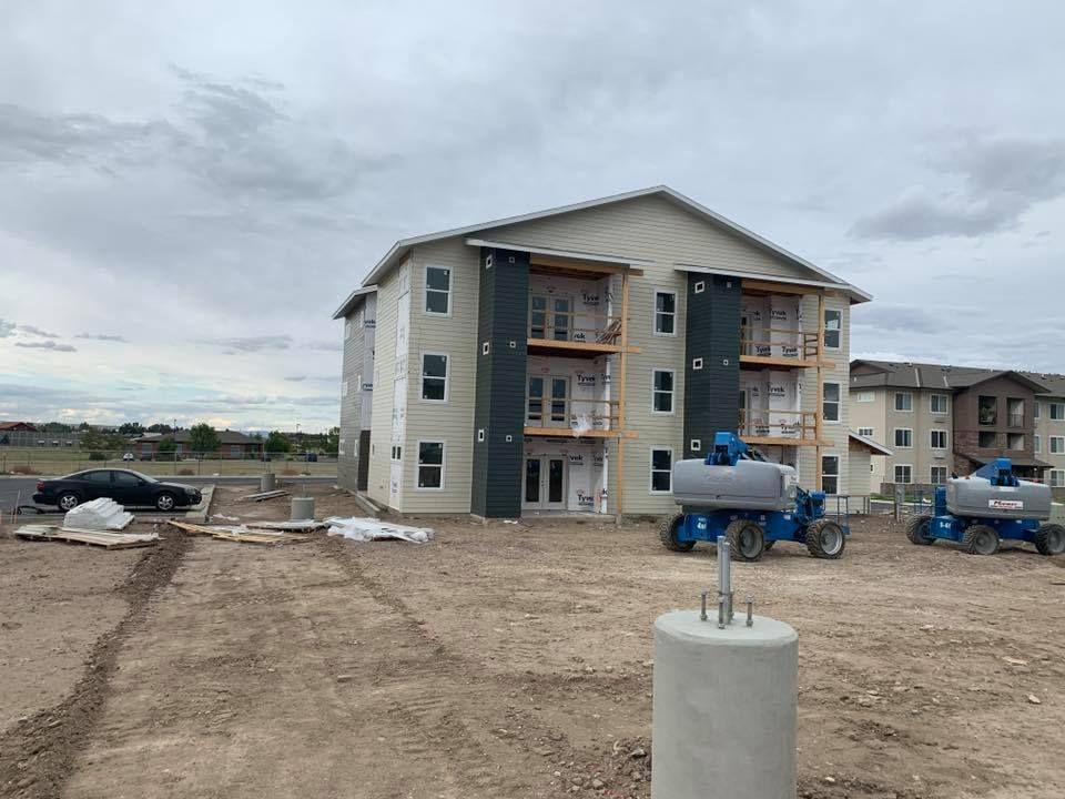 A yellow excavator is sitting on top of a pile of gravel.
