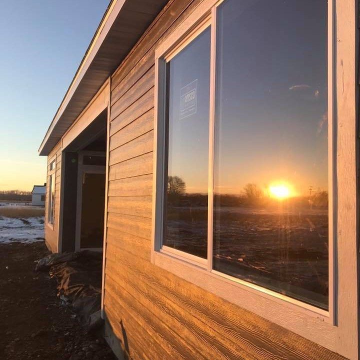 A yellow excavator is sitting on top of a pile of gravel.