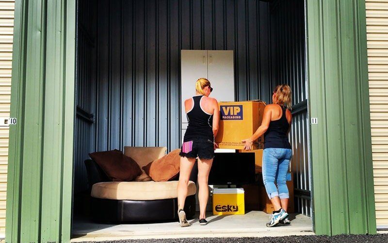 Women Carrying A Box Inside A Storage Unit — Storage Solutions in Pottsville, NSW
