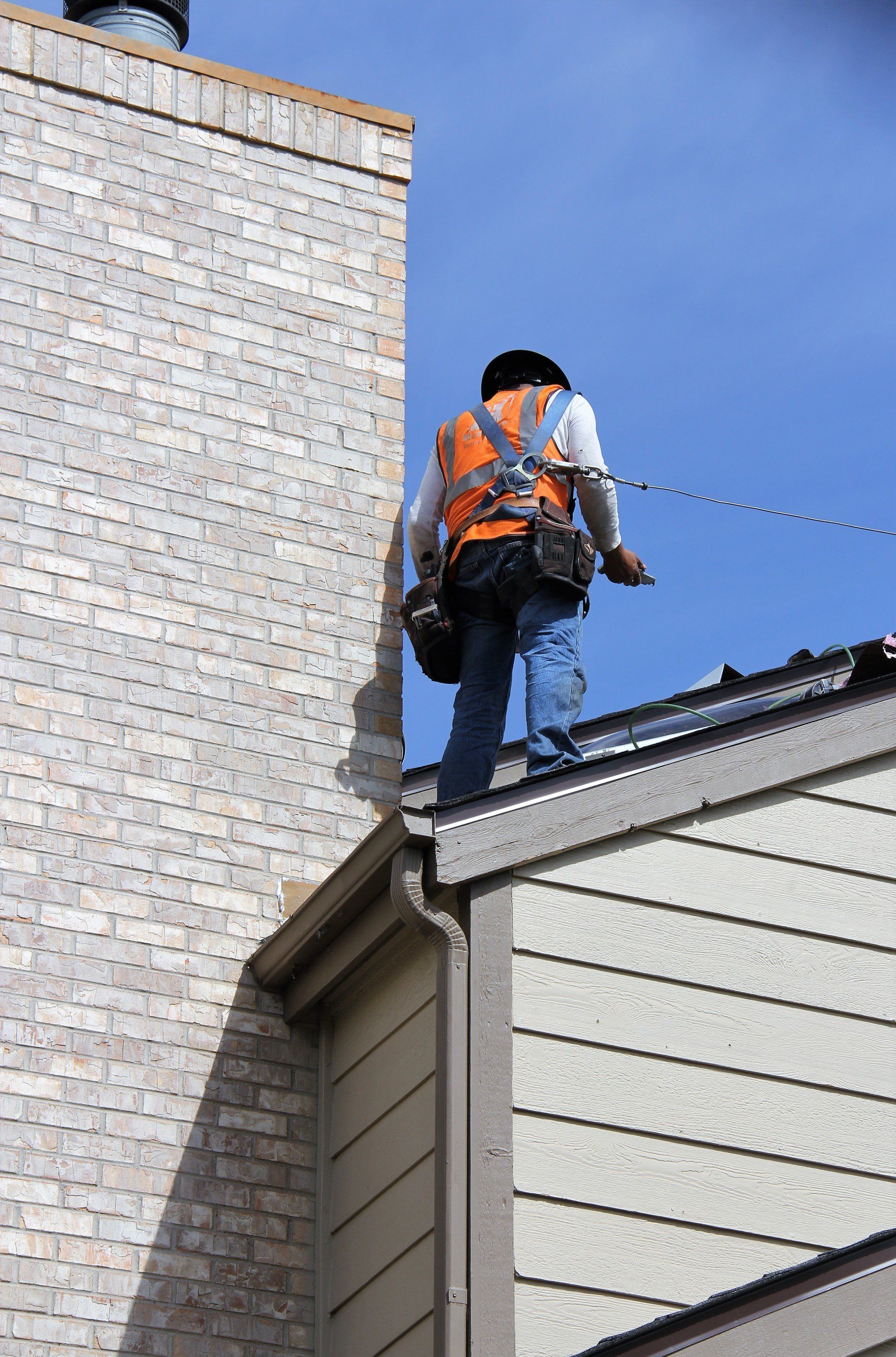 A crew member is tethered on a roof for safety