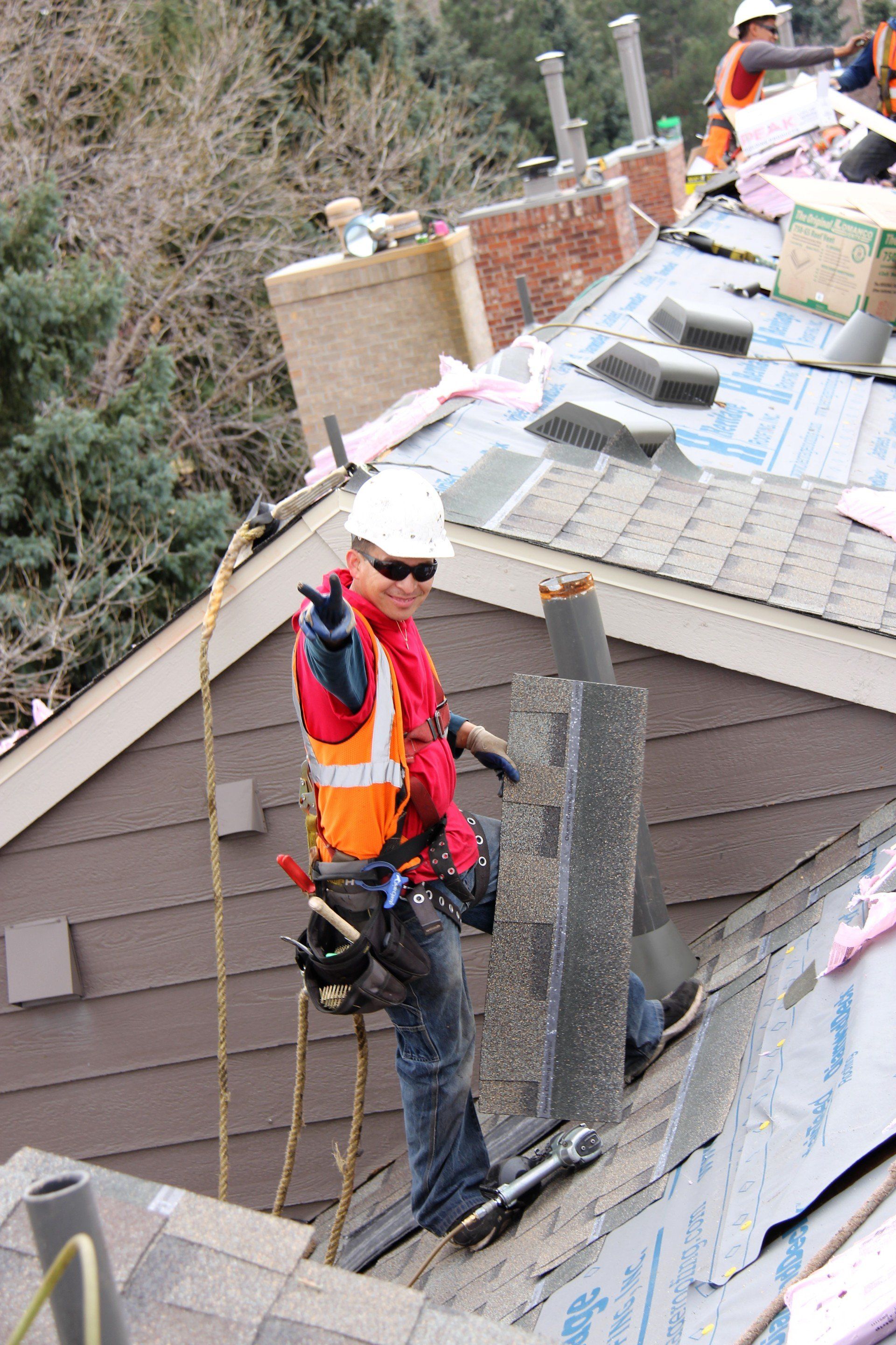 A crew member flashes a smile as he helps install a new roof.