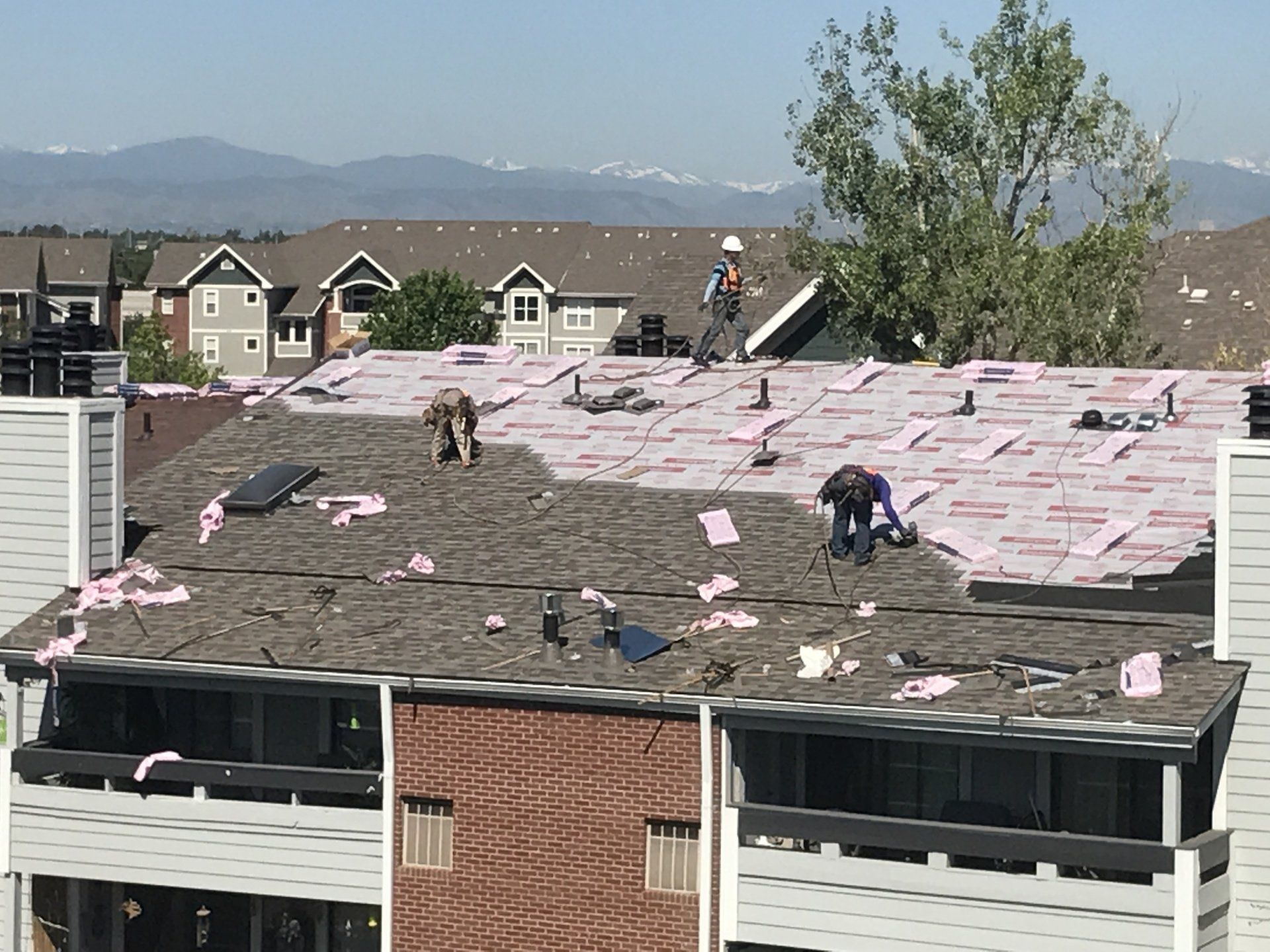 The crew gets a beautiful view of the Colorado mountains as they install shingles.