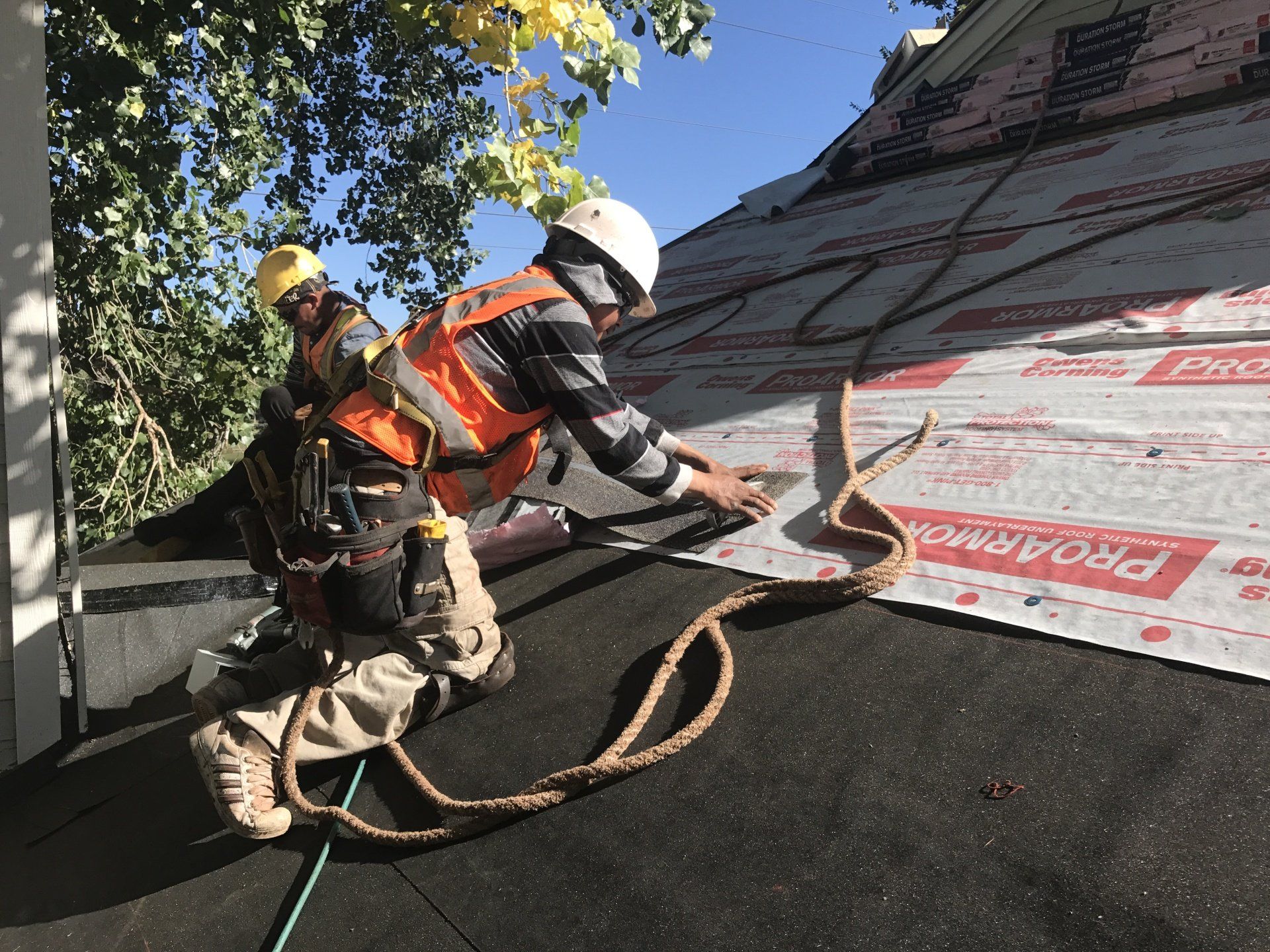 Up close of two crew members in the process of installing a roof.