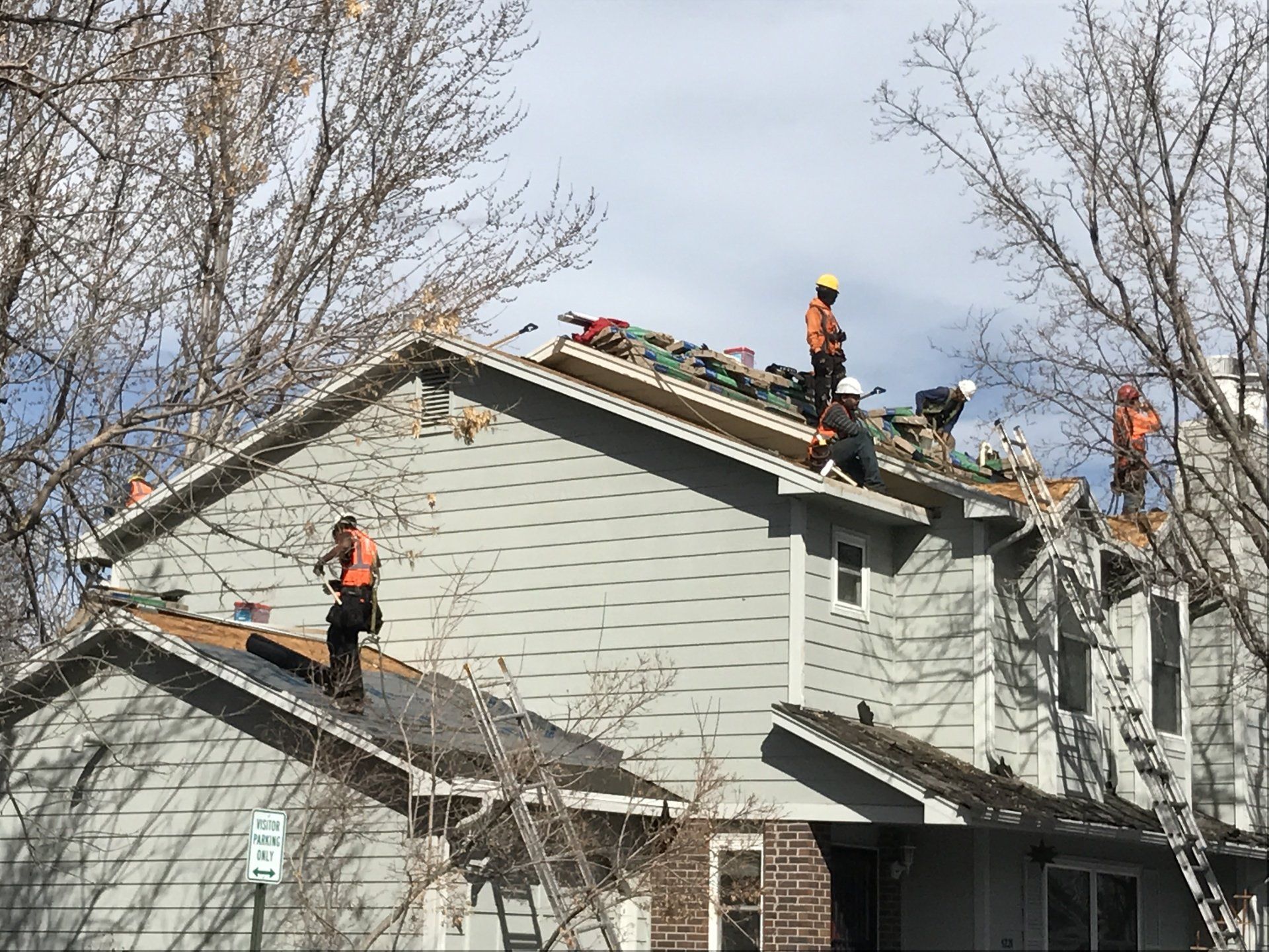 A crew is in the process of installing a roof on a multi-family unit.
